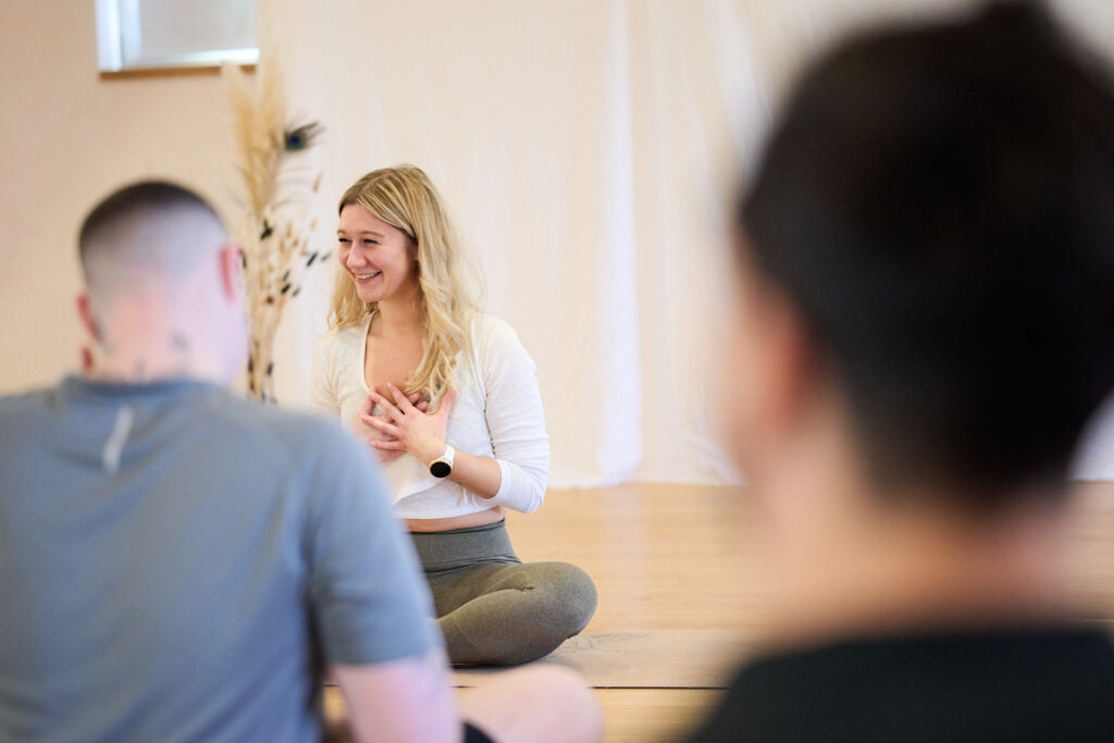 ein foto von Melissa wo sie in ihrer Yoga klasse lächelt und strahlt