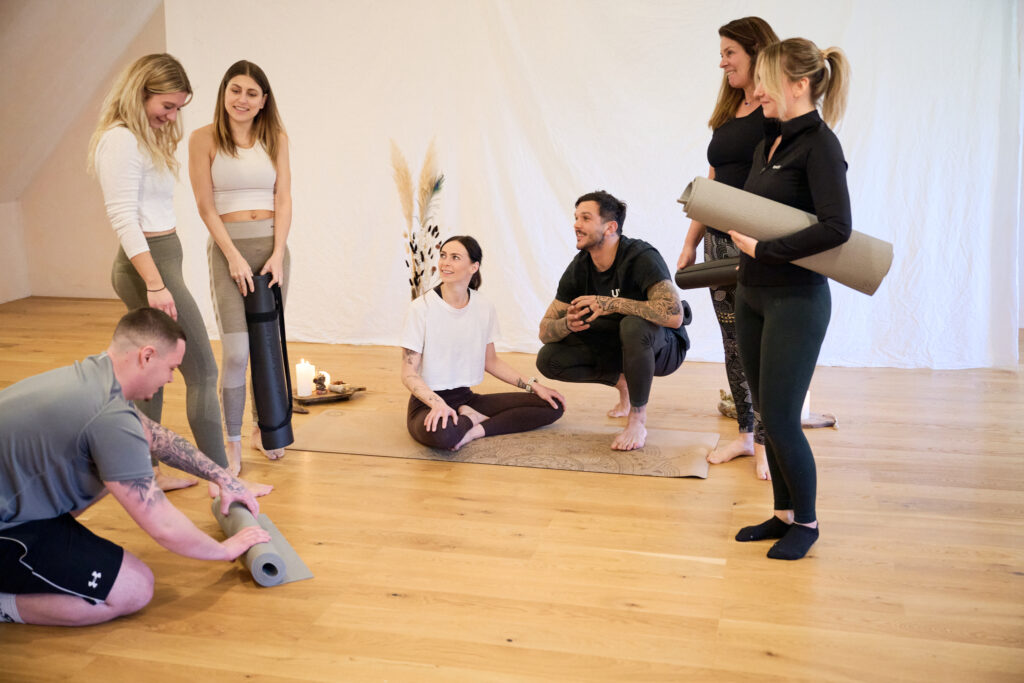 die Teilnehmer der Yogaklasse nach der Einheit beim plaudern